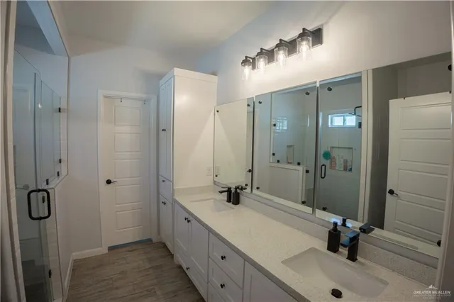 a bathroom with a double vanity sink mirror and shower