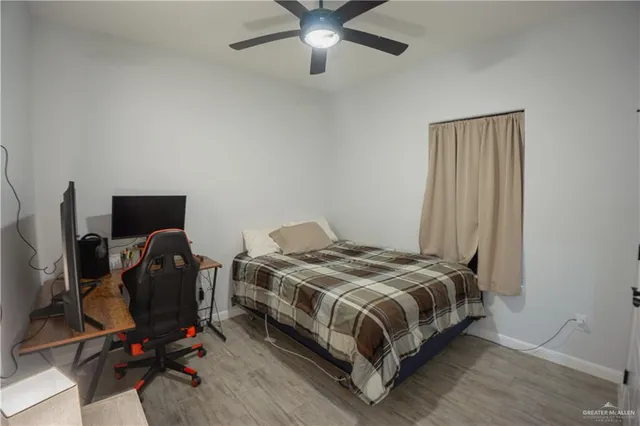 a bedroom with a bed and a computer on a desk