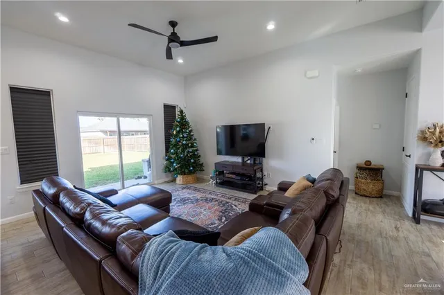 a living room with furniture a flat screen tv and a window