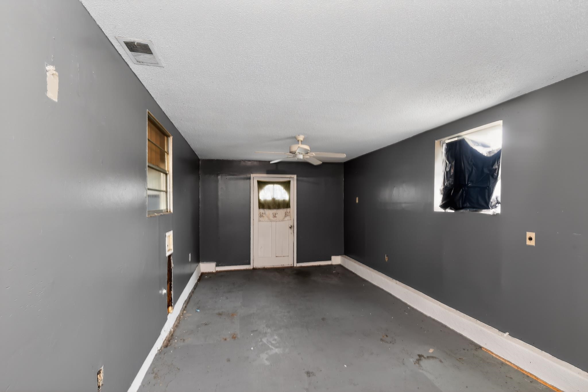 645 Parkrose Road Memphis, TN 38109 - Photo 26 of 32 Spacious room featuring a ceiling fan, two windows, and direct outdoor access
