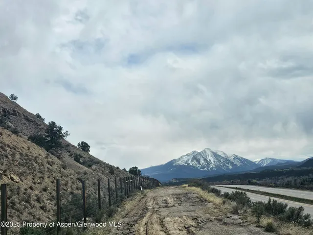 a view of a dry yard with mountains in the background