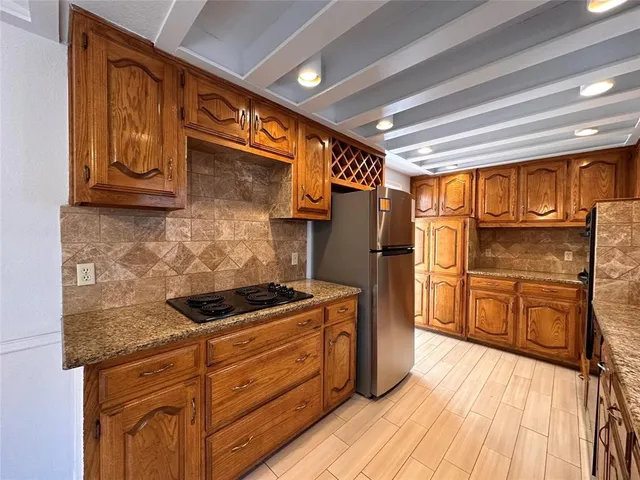 a kitchen with granite countertop stainless steel appliances and wooden cabinets