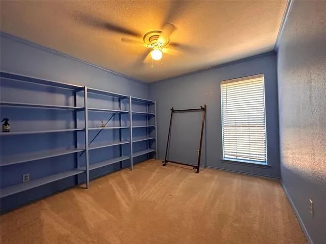 a view of an empty room with a fireplace and a window