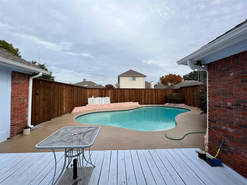1030 Clinton Street Carrollton, TX 75007 - Photo 4 of 33 a view of a patio with table and chairs with wooden floor and fence