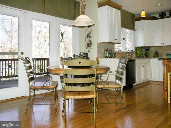 1300 Stamford Way Reston, VA 20194 - Photo 11 of 30 a kitchen with stainless steel appliances a dining table chairs and a white refrigerator