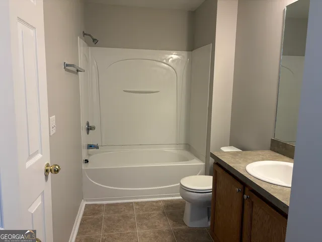 a bathroom with a granite countertop toilet a sink and a bathtub