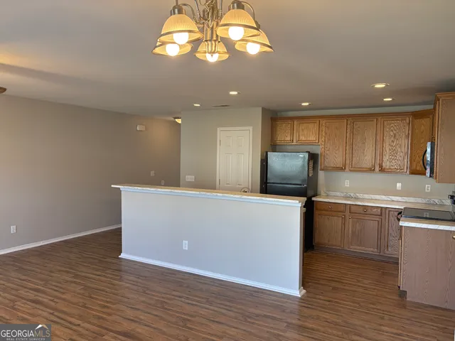 a kitchen with stainless steel appliances granite countertop a large counter top a stove and a refrigerator