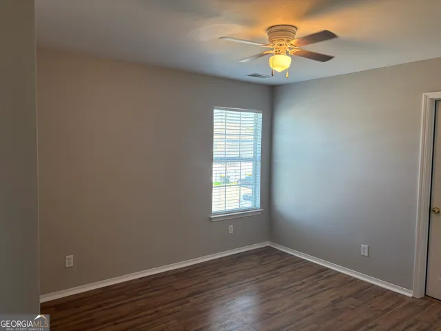 an empty room with wooden floor and a window