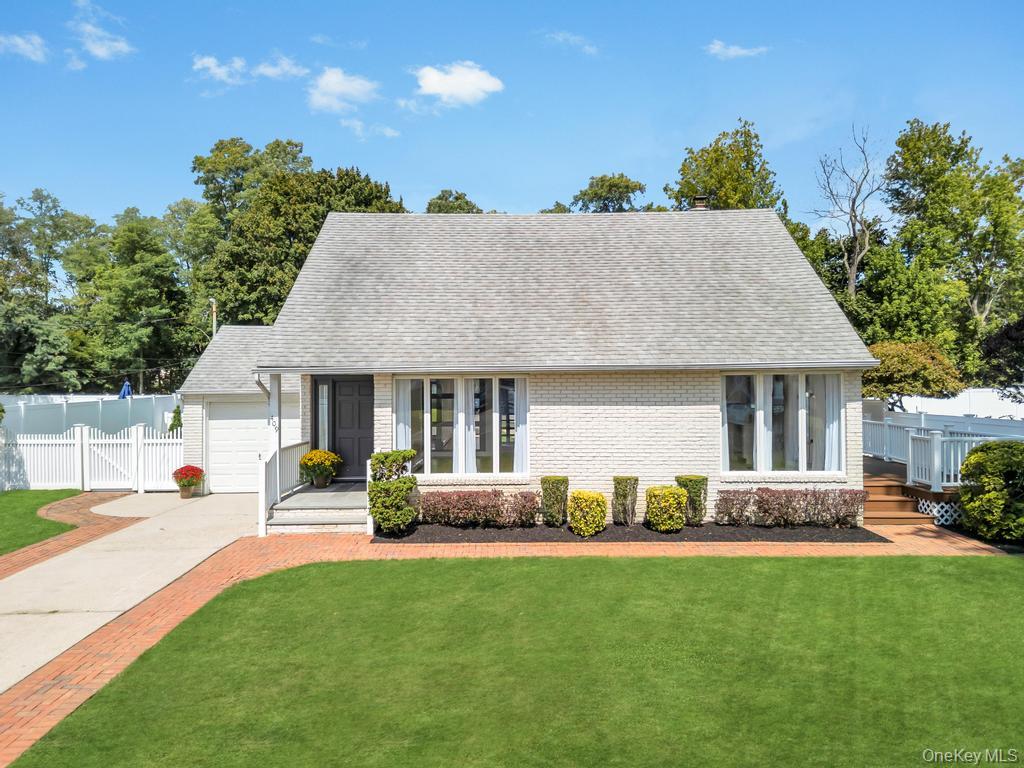 409 Capri Road West Islip, NY 11795 - Photo 1 of 1 View of front facade featuring roof with shingles, brick siding, driveway, and a garage