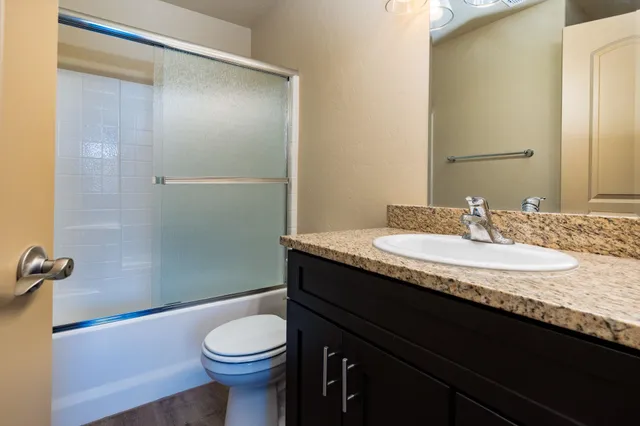 a bathroom with a granite countertop sink toilet and shower