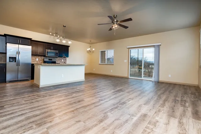 a view of a kitchen with a sink a refrigerator and a stove top oven