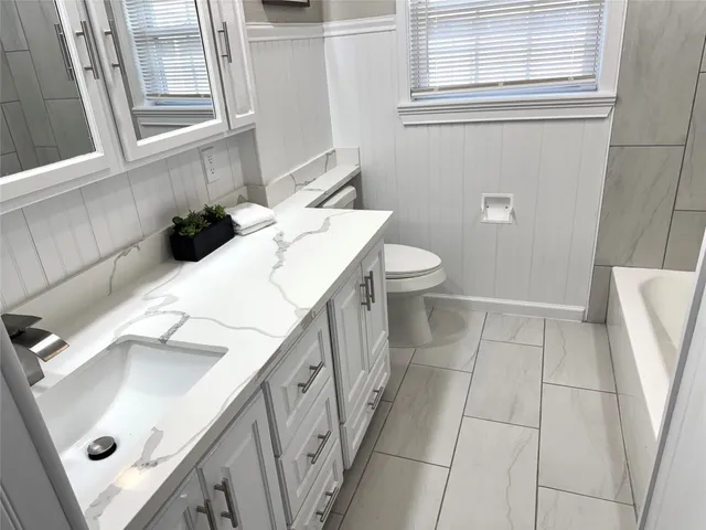 a bathroom with a sink a toilet and a window