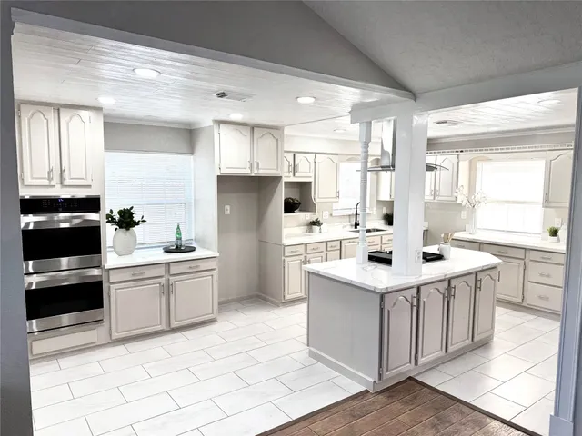 a kitchen with a sink a stove a refrigerator and white cabinets