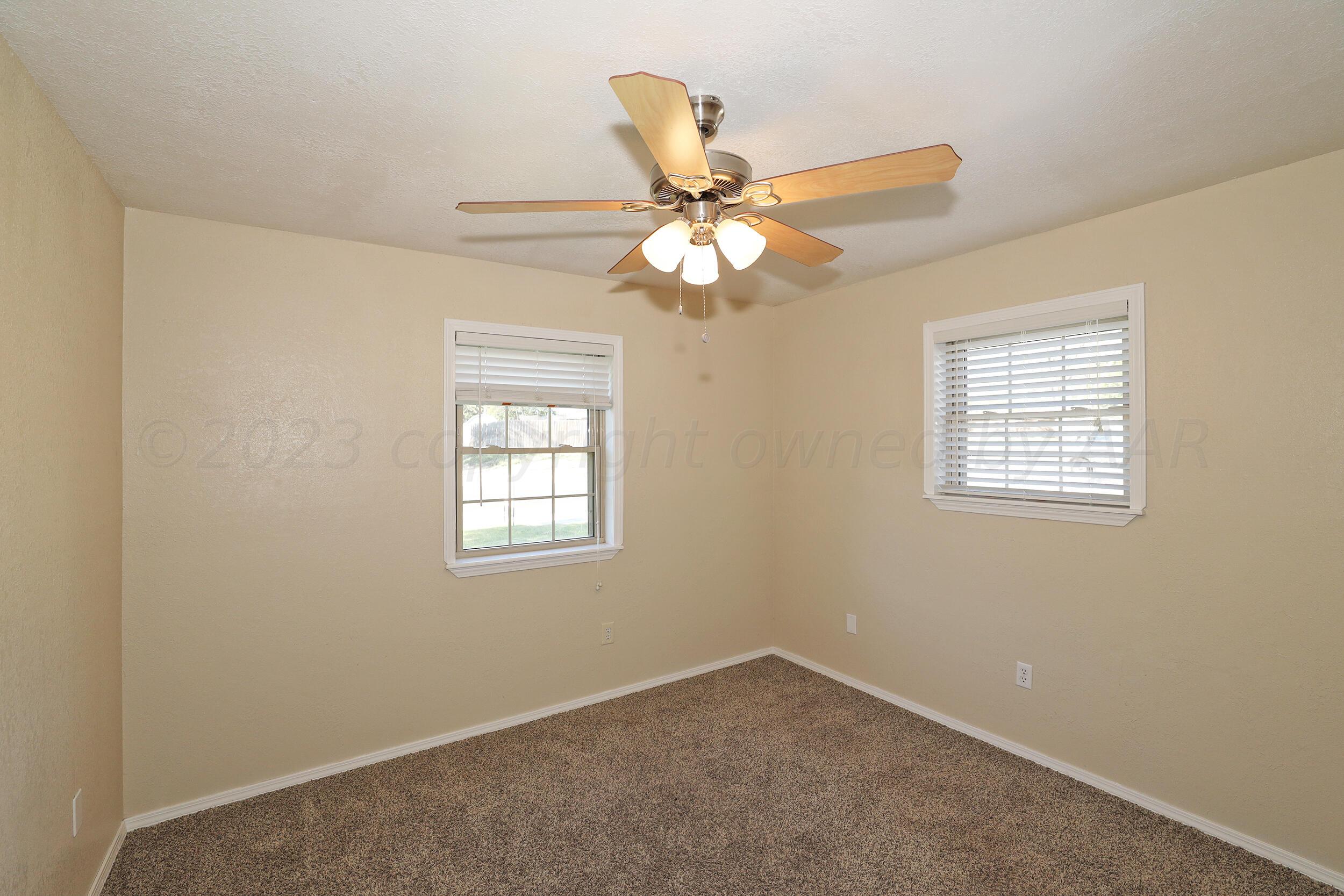 2905 Salem Drive Amarillo, TX 79110 - Photo 21 of 29 an empty room with windows and fan