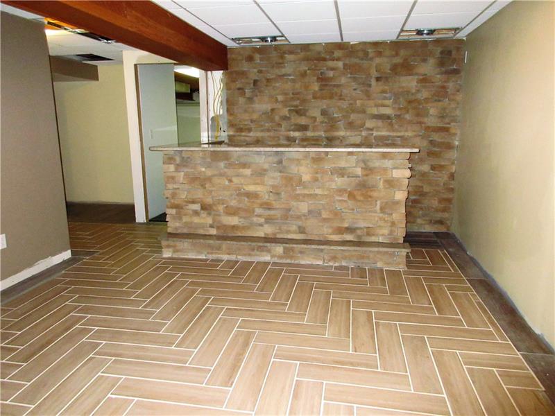 185 Mesa Drive Freeport, PA 16229 - Photo 18 of 25 The lower level family room is 90% finished but already has a stone bar with granite countertop, stone walls at both ends of the room, and ceramic tile flooring.