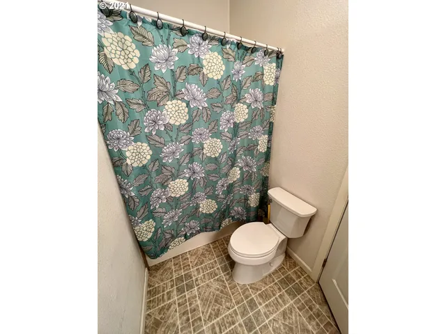 a bathroom with a toilet and shower curtain