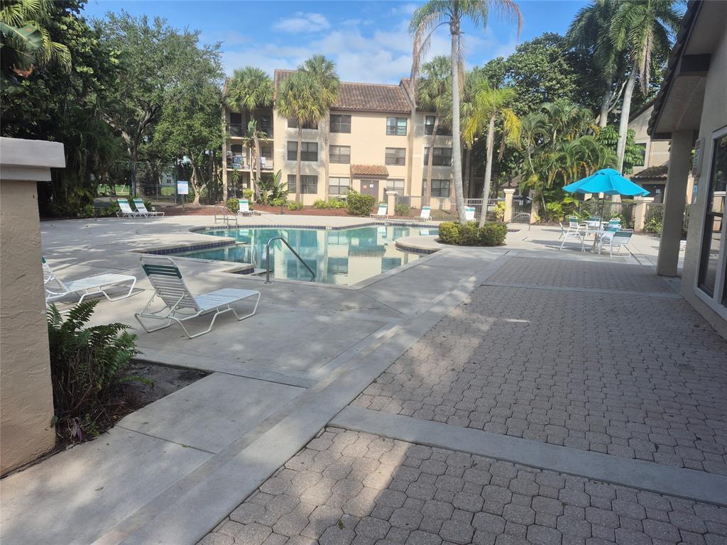 4481 West McNab Road, Unit 10 Pompano Beach, FL 33069 - Photo 3 of 16 a view of a patio with a table and chairs under an umbrella