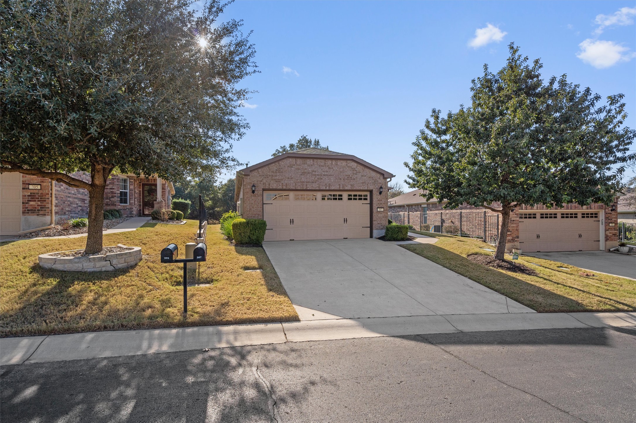 307 Kickapoo Creek Lane Georgetown, TX 78633 - Photo 2 of 30 Mature trees frame the neat driveway and brick exterior of this classic suburban residence.
