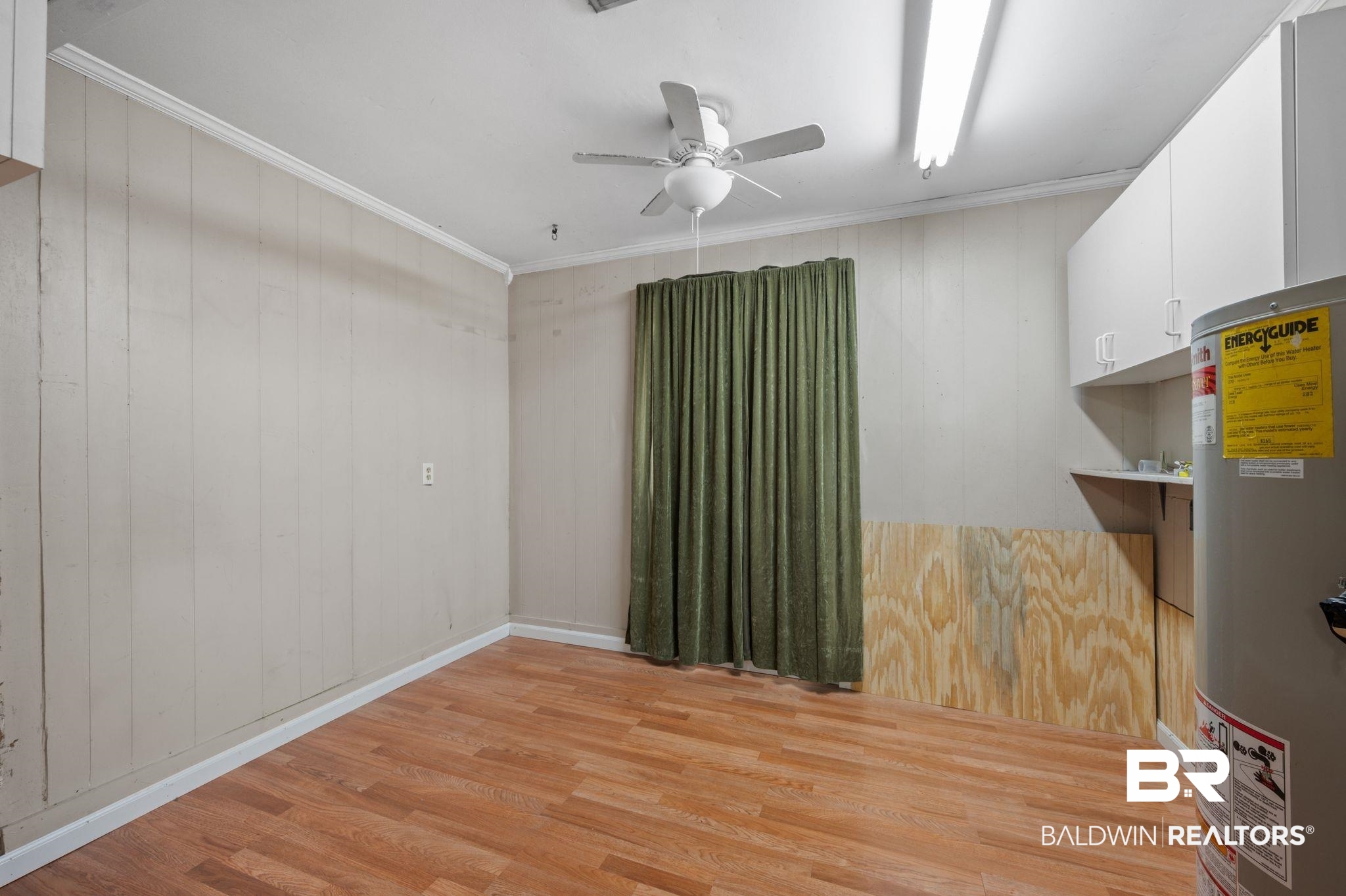 122 Rita Avenue Spanish Fort, AL 36527 - Photo 7 of 17 Spare room featuring water heater, crown molding, light wood-style flooring, and ceiling fan