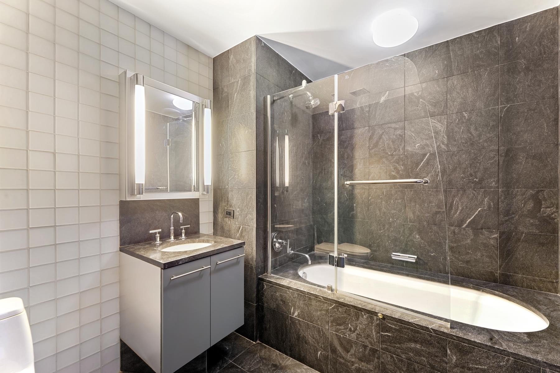 225 River Street, Unit 2003 Hoboken, NJ 07030 - Photo 12 of 19 a bathroom with a bathtub sink and mirror