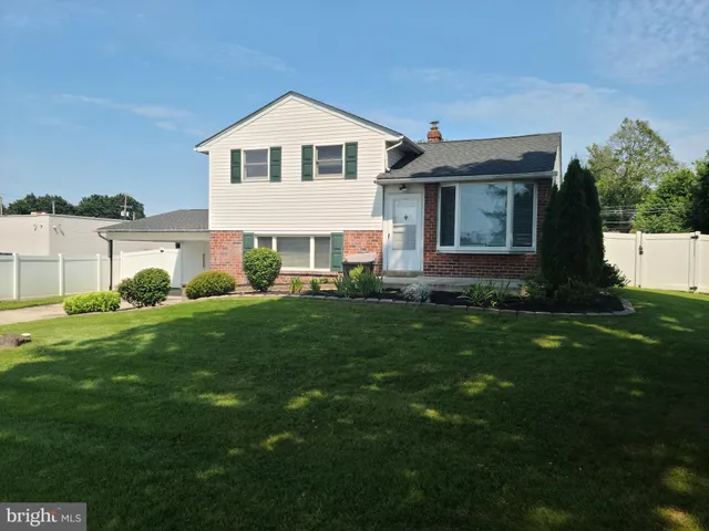a front view of a house with a garden and yard