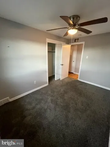 an empty room with closet and fan