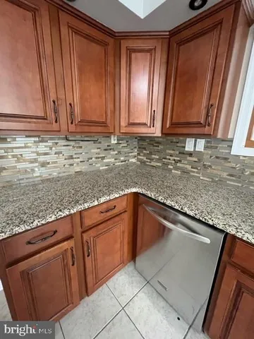 a kitchen with granite countertop a sink a stove and cabinets