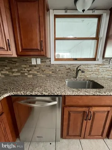 a kitchen with granite countertop a sink and a stove