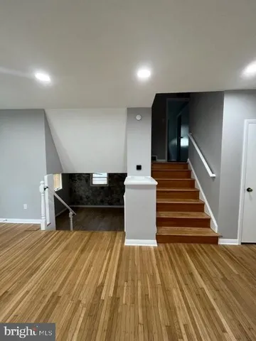 a living room with wooden floor and pool table