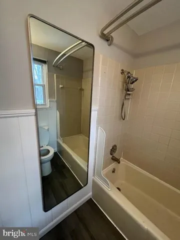 a bathroom with a tub a toilet and a shower