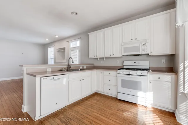 a kitchen with granite countertop white cabinets and white appliances