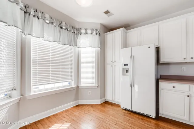 a view of a kitchen with wooden floor and a window