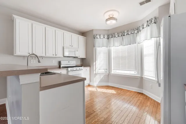 a kitchen with granite countertop a sink window and cabinets