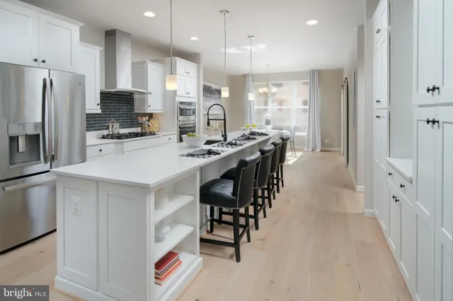 a kitchen with stainless steel appliances kitchen island granite countertop a refrigerator and a stove top oven