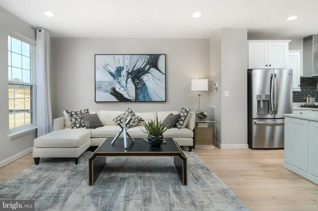 a living room with furniture and a white refrigerator