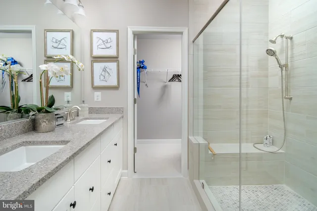 a bathroom with a granite countertop sink mirror and shower