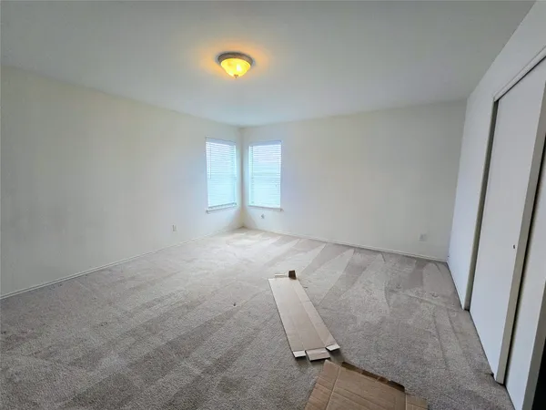 an empty room with a piano and wooden floor