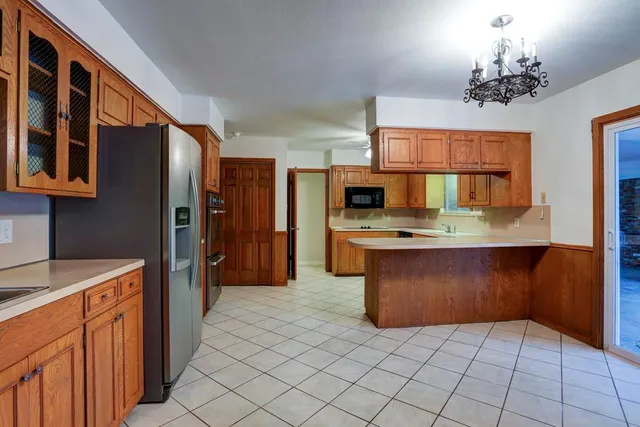 a kitchen with stainless steel appliances granite countertop a refrigerator and a stove top oven