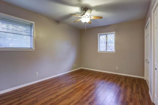 a view of wooden floor and a chandelier fan in a room
