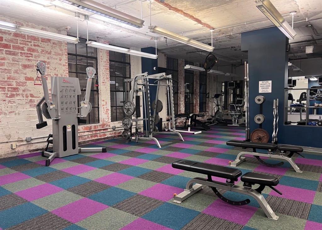 1122 Jackson Street, Unit 514 Dallas, TX 75202 - Photo 36 of 40 Dedicated fitness room featuring exposed brick walls, industrial-style windows, and a colorful checkered carpet