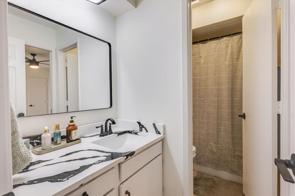 8105 Ravenswood Road Granbury, TX 76049 - Photo 10 of 28 Vanity with a black and white patterned countertop, undermount sink, and matte black faucet