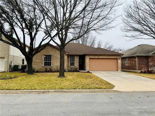 a front view of a house with a yard covered in snow