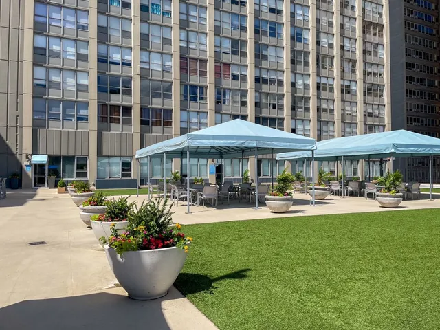a view of a patio with dining table and chairs under an umbrella