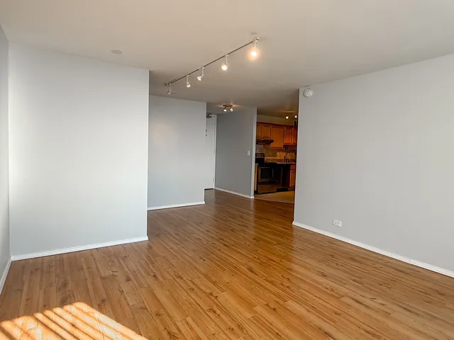 a view of an empty room with wooden floor
