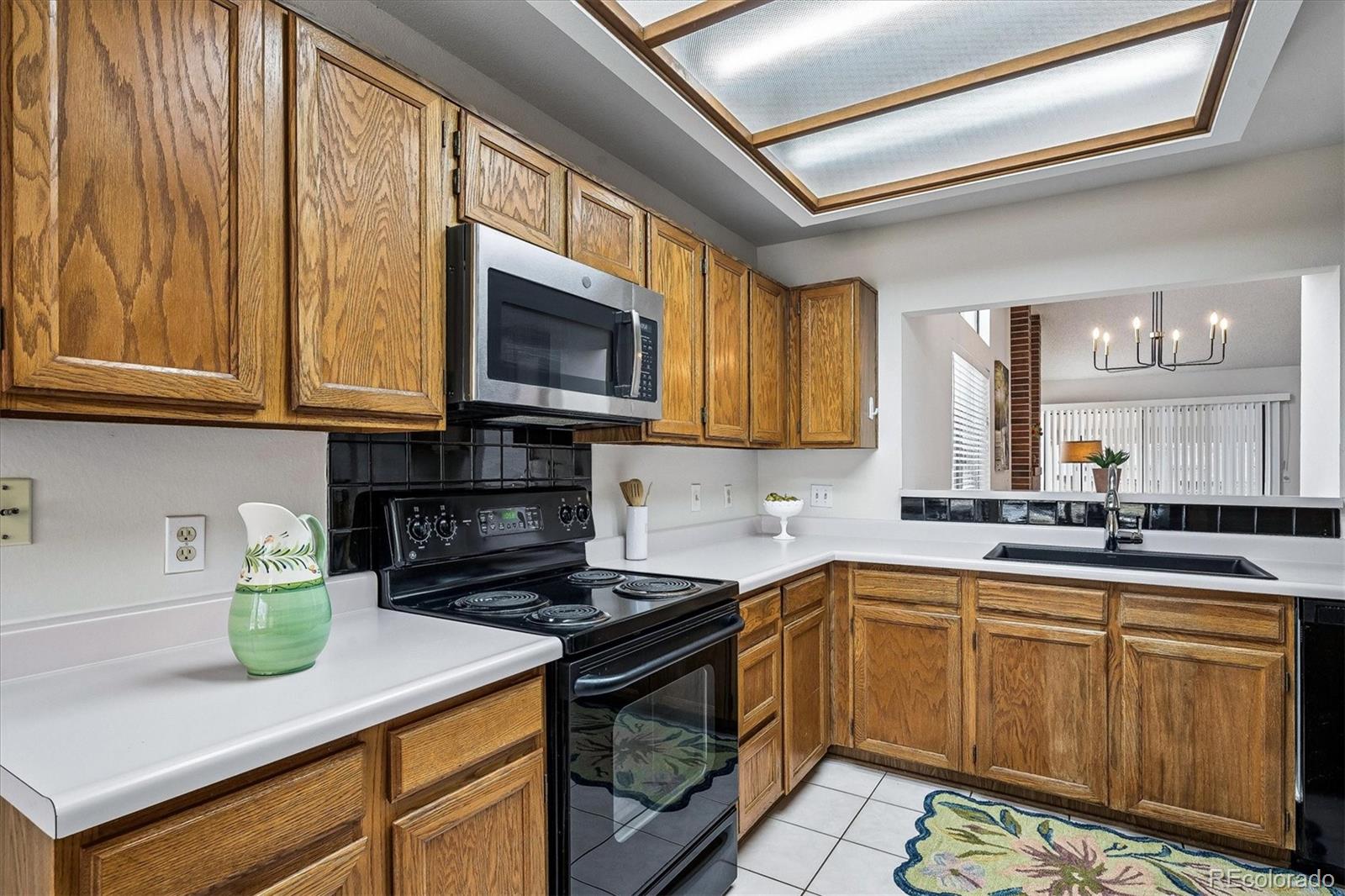 8624 Redstone Street Highlands Ranch, CO 80126 - Photo 11 of 26 a kitchen with stainless steel appliances granite countertop a sink stove and microwave