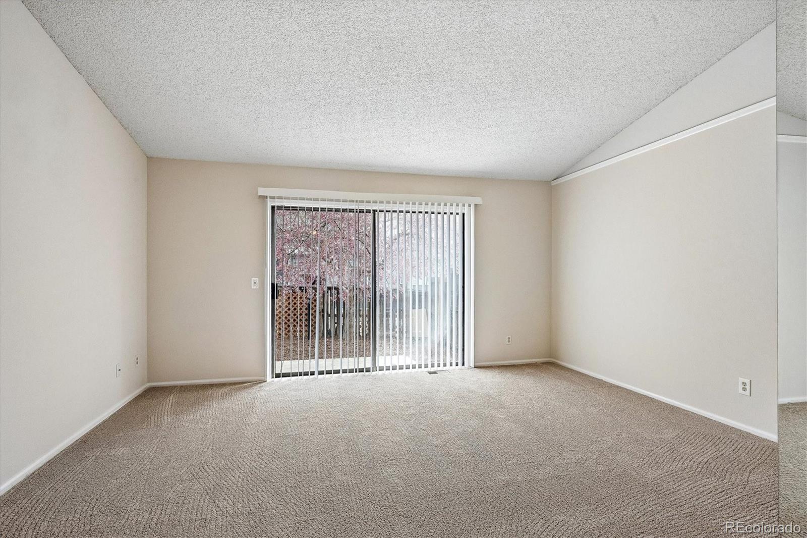 8624 Redstone Street Highlands Ranch, CO 80126 - Photo 12 of 26 an empty room with wooden floor and windows