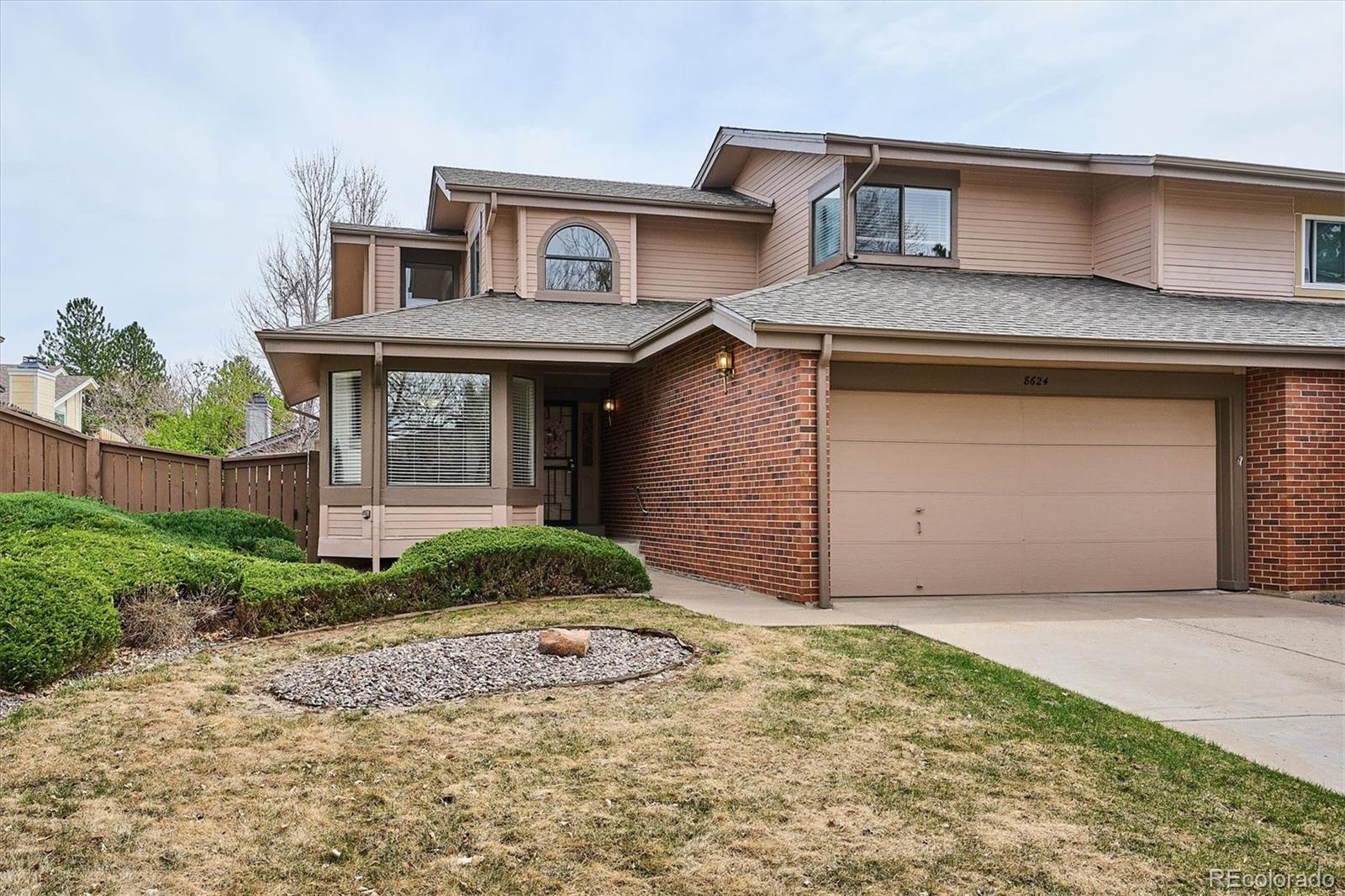 8624 Redstone Street Highlands Ranch, CO 80126 - Photo 2 of 26 a front view of a house with a yard and garage