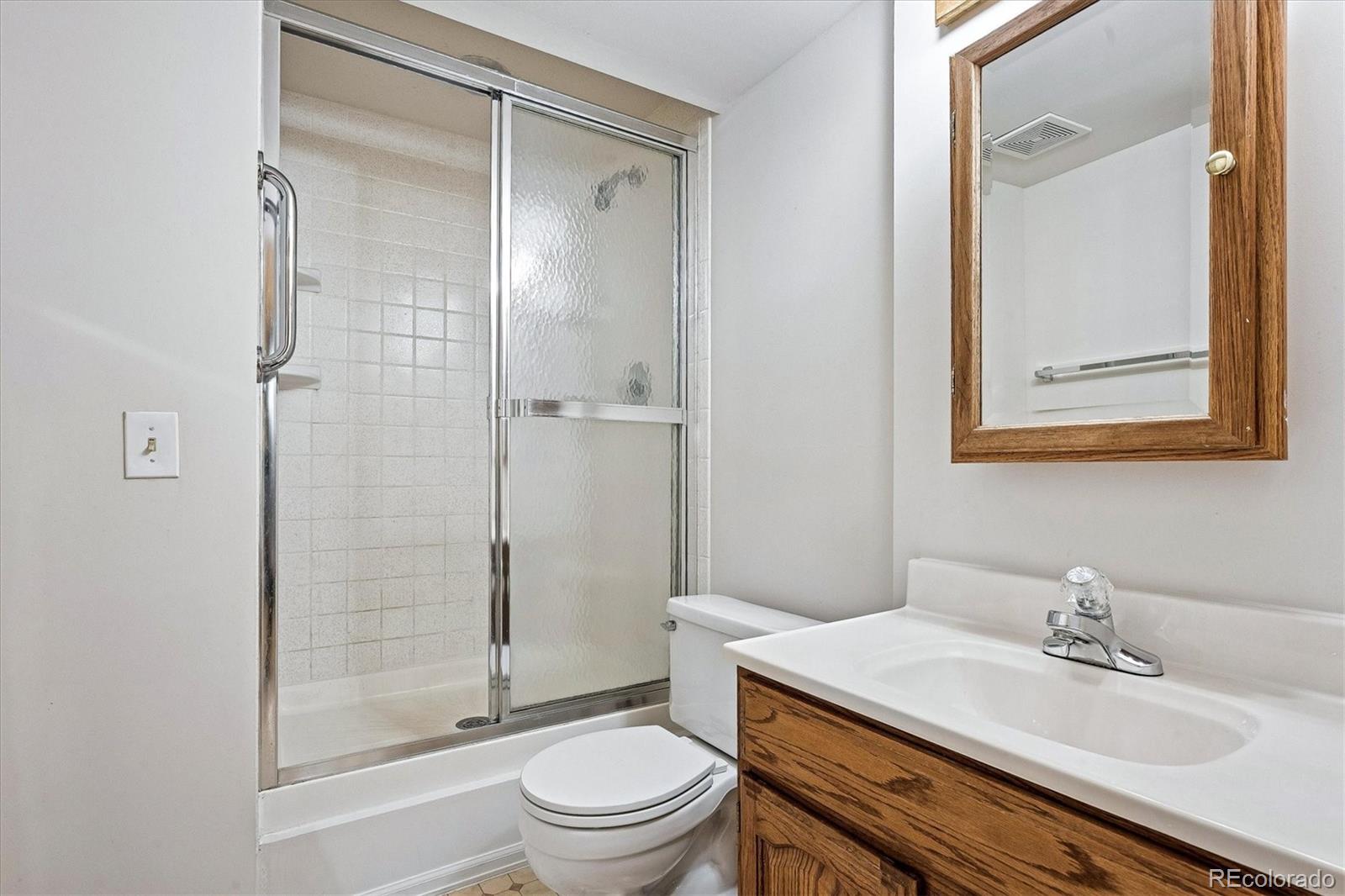 8624 Redstone Street Highlands Ranch, CO 80126 - Photo 23 of 26 a bathroom with a sink toilet vanity and shower