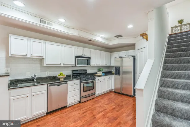 a kitchen with white cabinets and white appliances