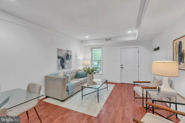 a living room with furniture and a wooden floor